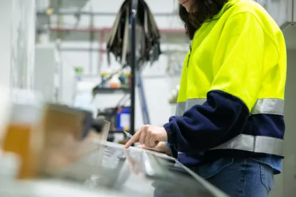 Industrial engineer programming machine at control panel. Cropped shot of woman in uniform working at plant. Manufacturing concept