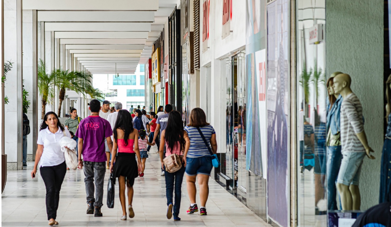Pessoas passeiam em uma avenidade comercial