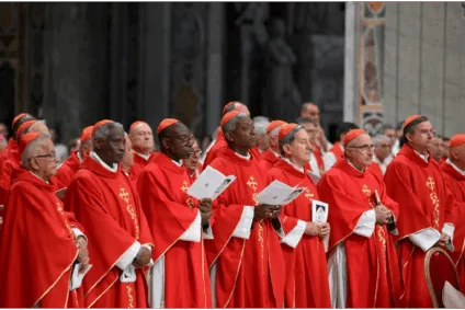 Cardeais vestidos de vermelhos enfileirados um do lado do outro. Imagem que ilustra a matéria: Conclave 2025: Quanto custa escolher um novo Papa?