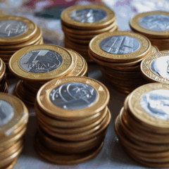 Moedas de 1 real empilhadas, simbolizando o acumulo da dívida publica.