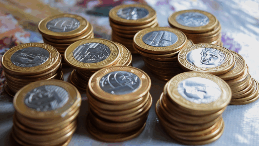 Moedas de 1 real empilhadas, simbolizando o acumulo da dívida publica.