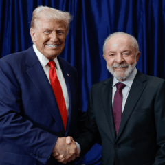 Presidente Lula e Trump de mãos dadas ao fundo as bandeiras de Brasil e EUA