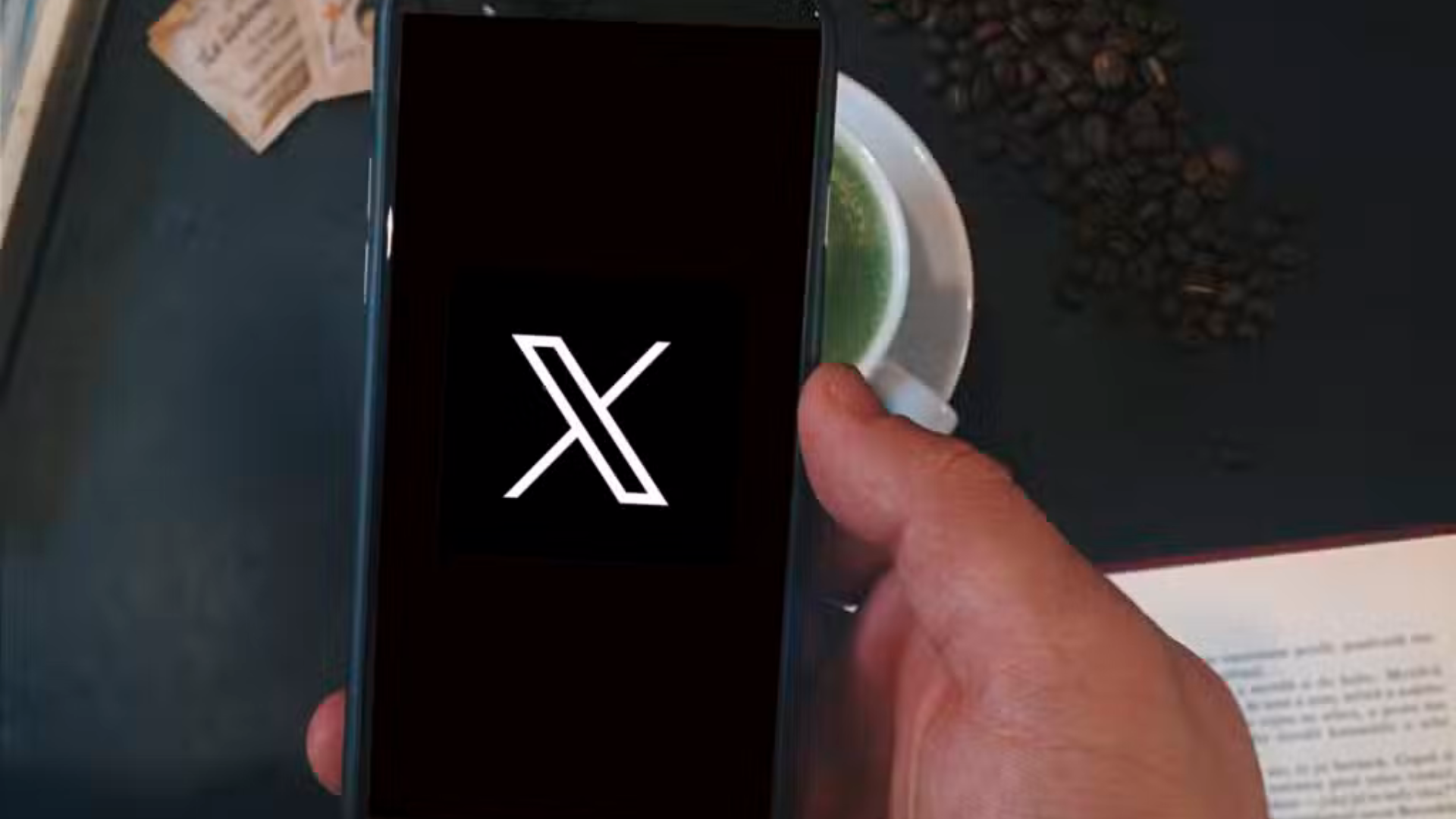 celular na mão com logo do X
